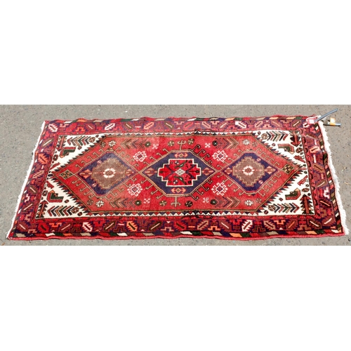 30 - A red ground medallion rug