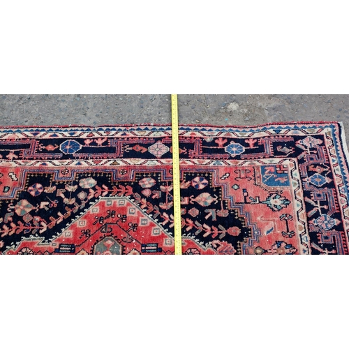 31 - A red and blue ground medallion rug