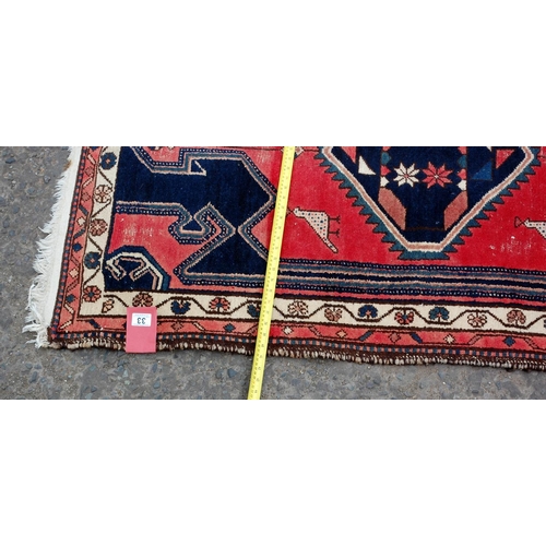 33 - A small red and blue ground rug