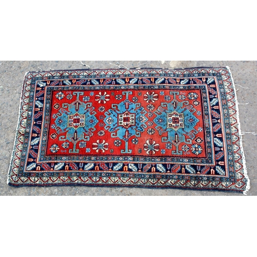 36 - A red and blue ground medallion rug