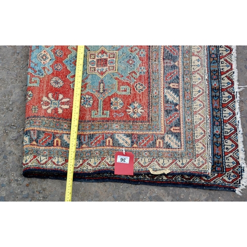 36 - A red and blue ground medallion rug