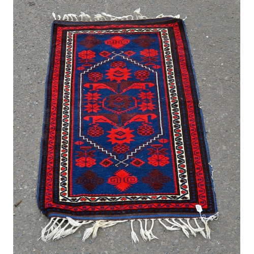107 - A small red and black ground rug with central medallion