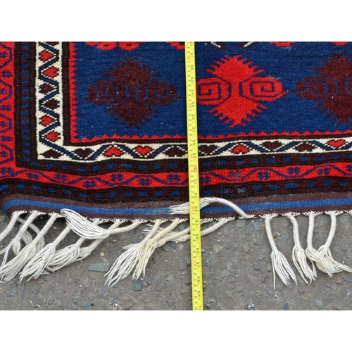 107 - A small red and black ground rug with central medallion