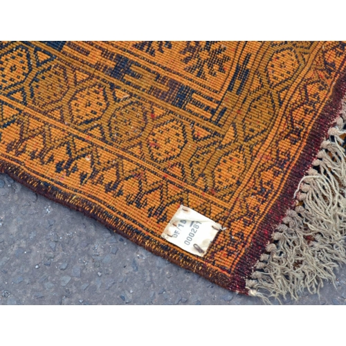 108 - A large orange ground rug with 3 central medallions