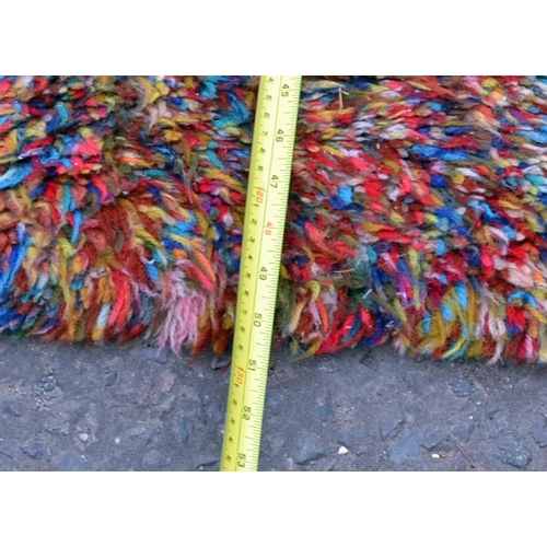 115 - A multi- coloured fluffy rug