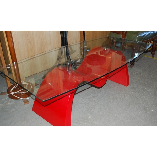 81 - A retro glass topped coffee table with red base - Postage/packing not available.