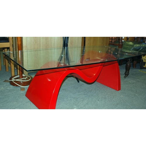 81 - A retro glass topped coffee table with red base - Postage/packing not available.