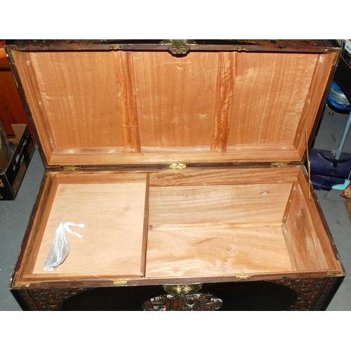 105 - A vintage Oriental camphorwood chest with carved details - Postage/packing not available.