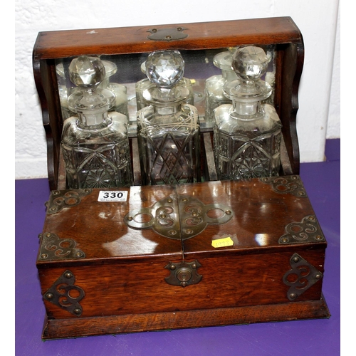 330 - An antique oak cased 3 bottle tantalus - Postage/packing not available