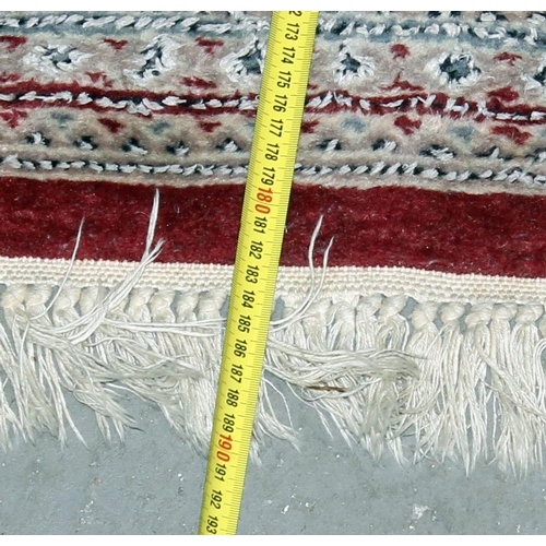 256 - A red and silver ground medallion rug