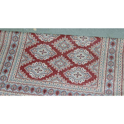 256 - A red and silver ground medallion rug