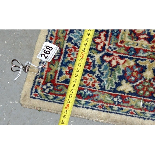 268 - A cream and red ground rug with large medallion