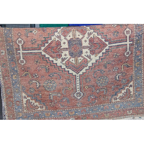 271 - An antique blue and red ground rug with 2 central medallions