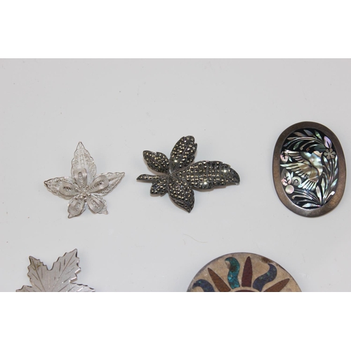 1258 - 7 silver and white metal pendants and brooches