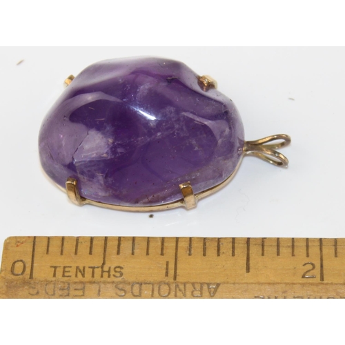 1264 - A large purple stone pendant (believed to be an uncut Amethyst) in a yellow metal mount marked 14k