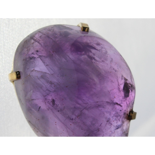 1264 - A large purple stone pendant (believed to be an uncut Amethyst) in a yellow metal mount marked 14k