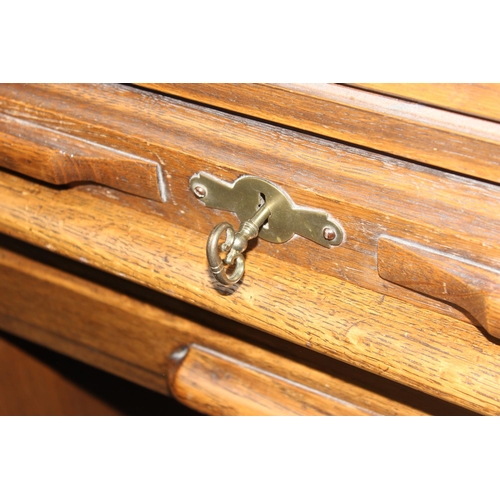 141 - An early 20th century Oak roll-top desk with key