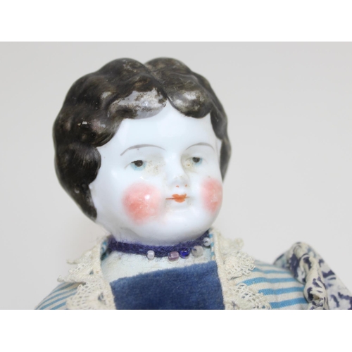 1477 - An antique porcelain headed doll with vintage dress in the manner of Biedermeier