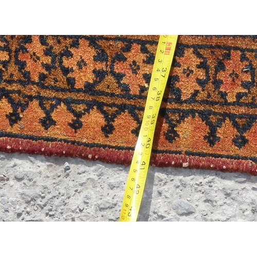 251 - A vintage orange ground triple medallion rug