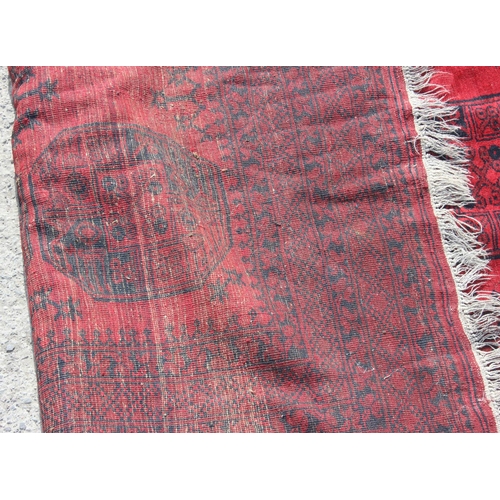 255 - A large red and black ground Afghan 10 medallion rug with concentric geometric borders