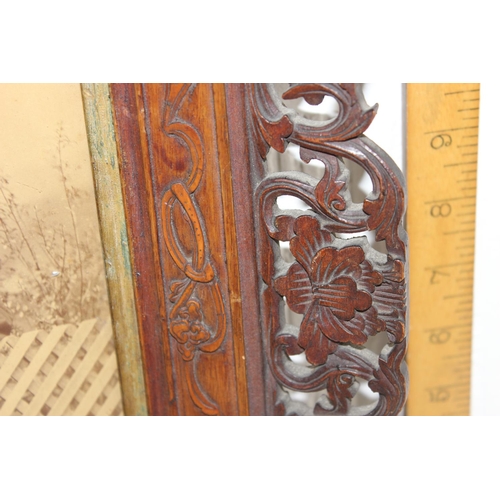 411 - An antique group photo of gentlemen set within a highly decorative Oriental carved wooden frame