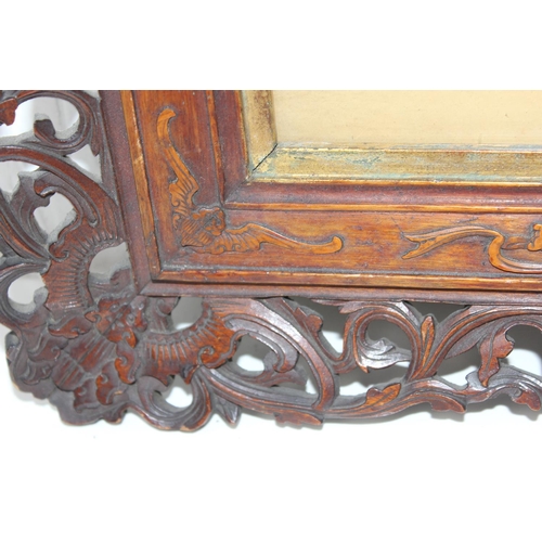 411 - An antique group photo of gentlemen set within a highly decorative Oriental carved wooden frame