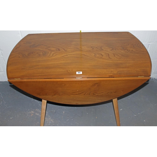 95 - A Blonde Ercol drop leaf circular dining table