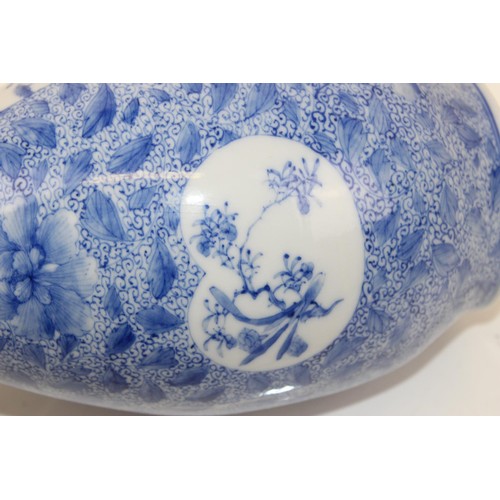 1671 - A 20th century Japanese blue and white decorated with floral vignettes - signed verso