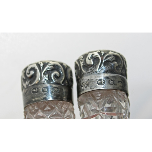 1130 - A pair of silver-topped and cut-glass scent bottles, a silver napkin ring and a silver thimble