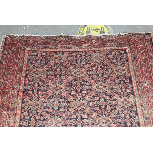 203 - A Mashad style rug on red ground with repeating geometric patterns - likely Persian - purchased from... 