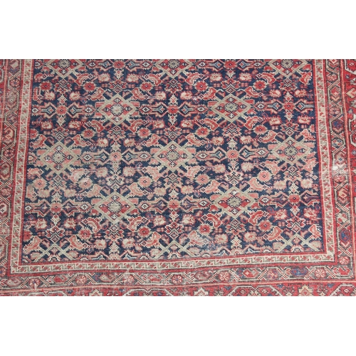 203 - A Mashad style rug on red ground with repeating geometric patterns - likely Persian - purchased from... 