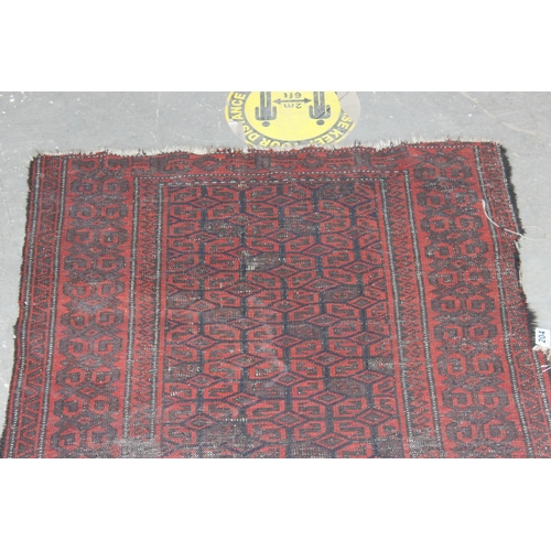 204 - An antique red ground rug decorated with and optical illusion of repeating gul - purchased from Harr... 