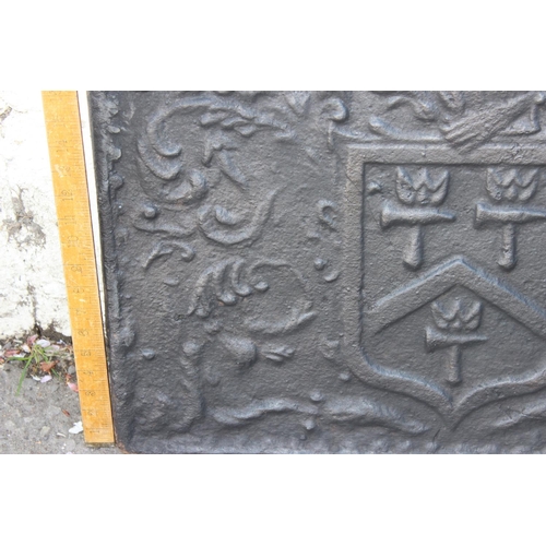 275 - A cast iron fire back of some age depicting a Phoenix and armorial crest