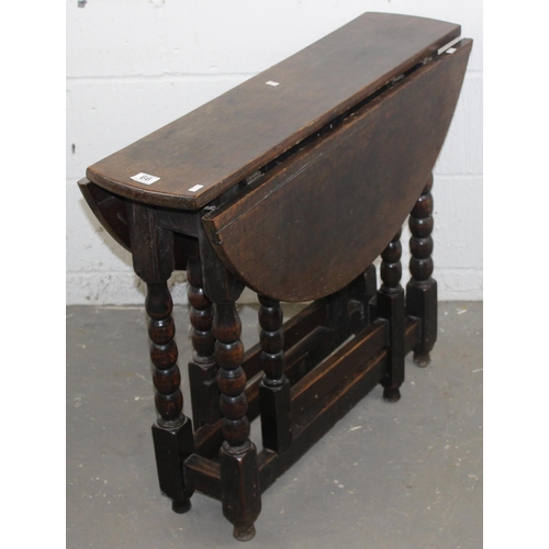 66 - An antique oak table with 2 folding leaves on bobbin turned legs and square stretchers, believed to ... 