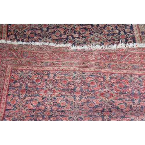 203 - A Mashad style rug on red ground with repeating geometric patterns - likely Persian - purchased from... 