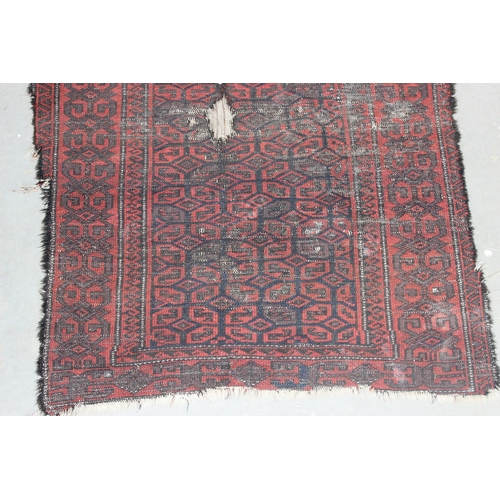 204 - An antique red ground rug decorated with and optical illusion of repeating gul - purchased from Harr... 