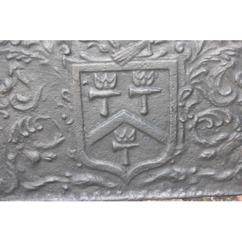 275 - A cast iron fire back of some age depicting a Phoenix and armorial crest