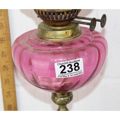 238 - An Art Deco period oil lamp with cranberry glass reservoir