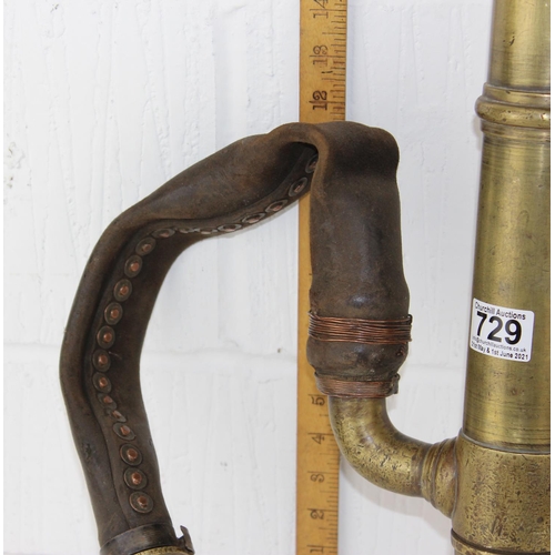 729 - An antique brass pump with unusual leather hose attachment