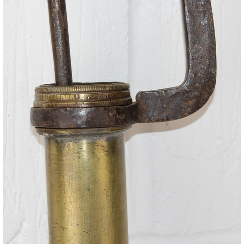 729 - An antique brass pump with unusual leather hose attachment