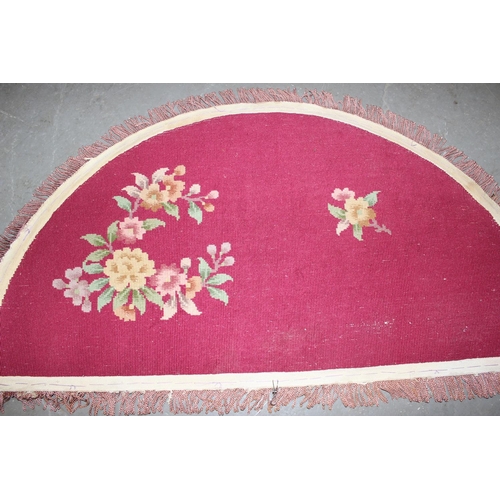 221a - A demi-lune rug decorated with flowers on a red ground - believed to be of Chinese or Indian  origin