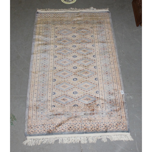 222 - A cream and blue ground rug decorated with Gul - believed to be of Pakistani origin with hand-knotte... 