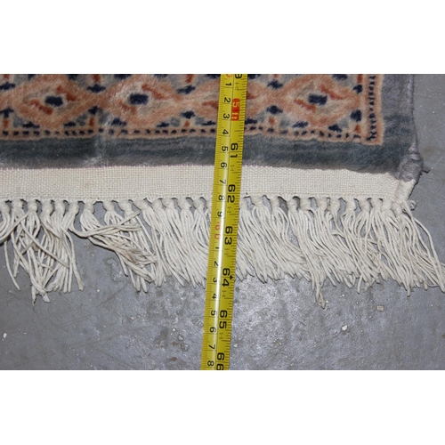 222 - A cream and blue ground rug decorated with Gul - believed to be of Pakistani origin with hand-knotte... 