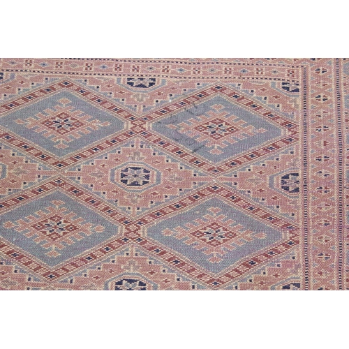 222 - A cream and blue ground rug decorated with Gul - believed to be of Pakistani origin with hand-knotte... 