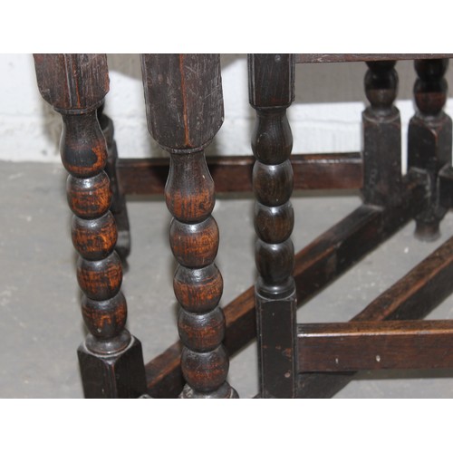 66 - An antique oak table with 2 folding leaves on bobbin turned legs and square stretchers, believed to ... 