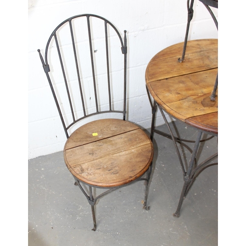 24 - A wrought iron and wooden table with 2 chairs