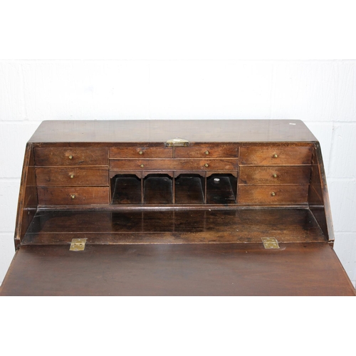 62 - A Georgian Oak bureau standing on bracket feet with brass handles