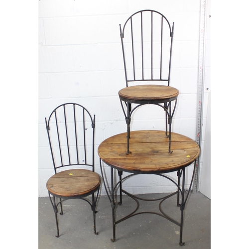 24 - A wrought iron and wooden table with 2 chairs