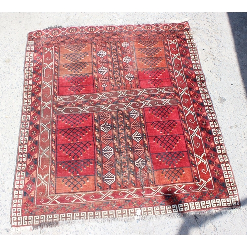 202 - An unusual antique red ground rug with latch hook border - possibly a prayer rug