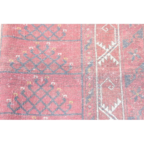 202 - An unusual antique red ground rug with latch hook border - possibly a prayer rug